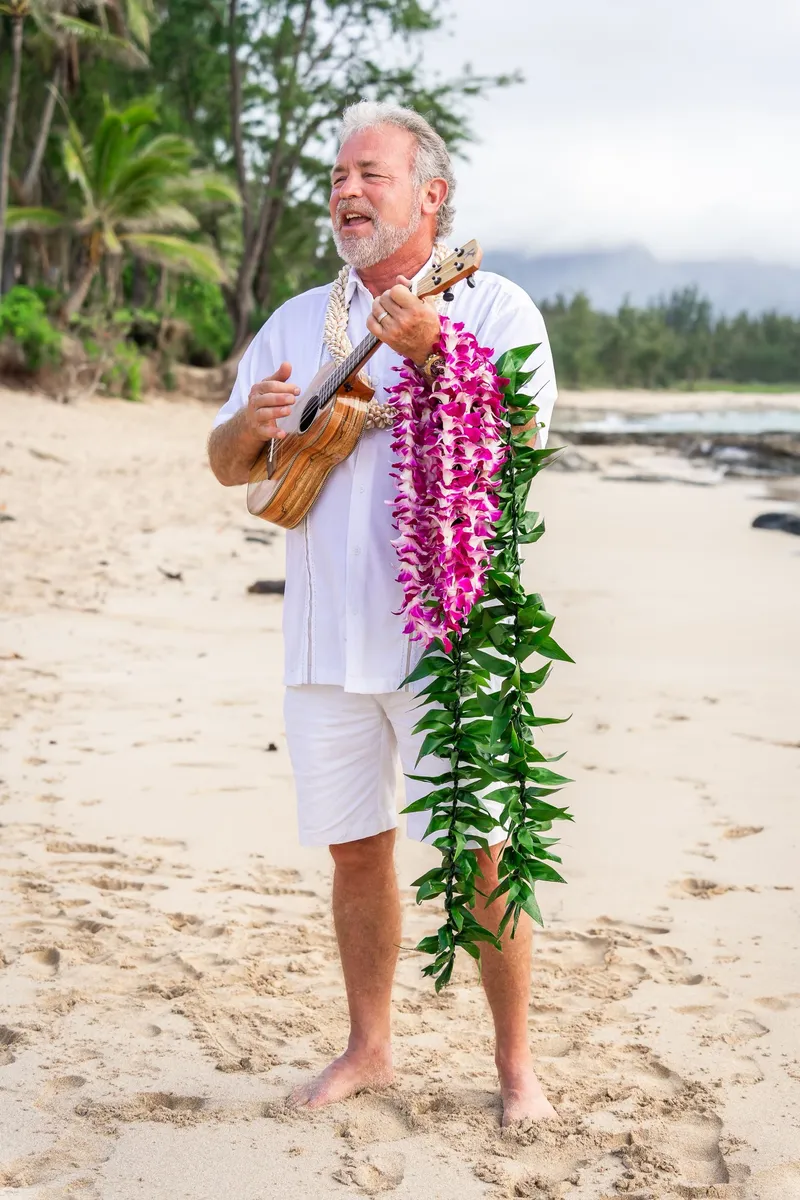 Pastor Mark Turansky holding a ukulele and wearing lei